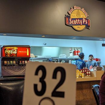 Scotty P's - a woman sitting at a table - Burgers Near Me - Plano, Texas