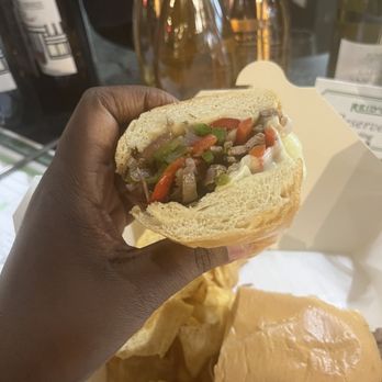Reid's Fine Foods - a hand holding a sandwich - Beer, Wine & Spirits Near Me - Charlotte, North Carolina