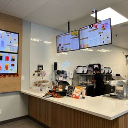 a restaurant counter with a menu on the wall
