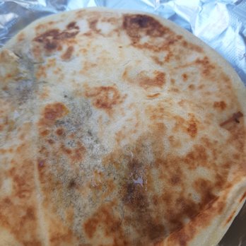 Barbacoa El Primo - A quesadilla with browned, crispy spots on its surface, placed on crinkled aluminum foil. - Mexican Near Me - Albuquerque, New Mexico