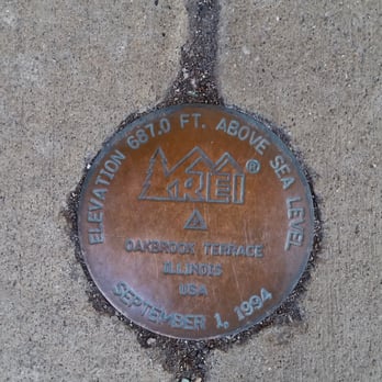 REI - REI's geodetic survey marker outside the front doors. - Bikes Near Me - Oakbrook Terrace, Illinois