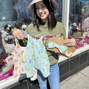 Silver Moon Kids - Erika is holding some of our rompers with matching headbands. - Children's Clothing Near Me - Oakland, California Silver Moon Kids - Erika is holding some of our rompers with matching headbands. - Children's Clothing Near Me - Oakland, California