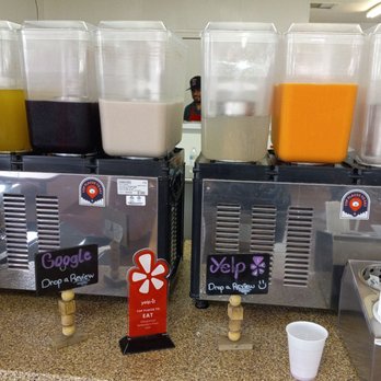 Barbacoa El Primo - They're in the top 100 restaurants in the SW. Thanks Yelp for letting me know. - Six beverage dispensers with various liquids, including yellow, dark purple, white, clear, orange, and a transparent container, are arranged on a countertop in a casual setting. - Mexican Near Me - Albuquerque, New Mexico