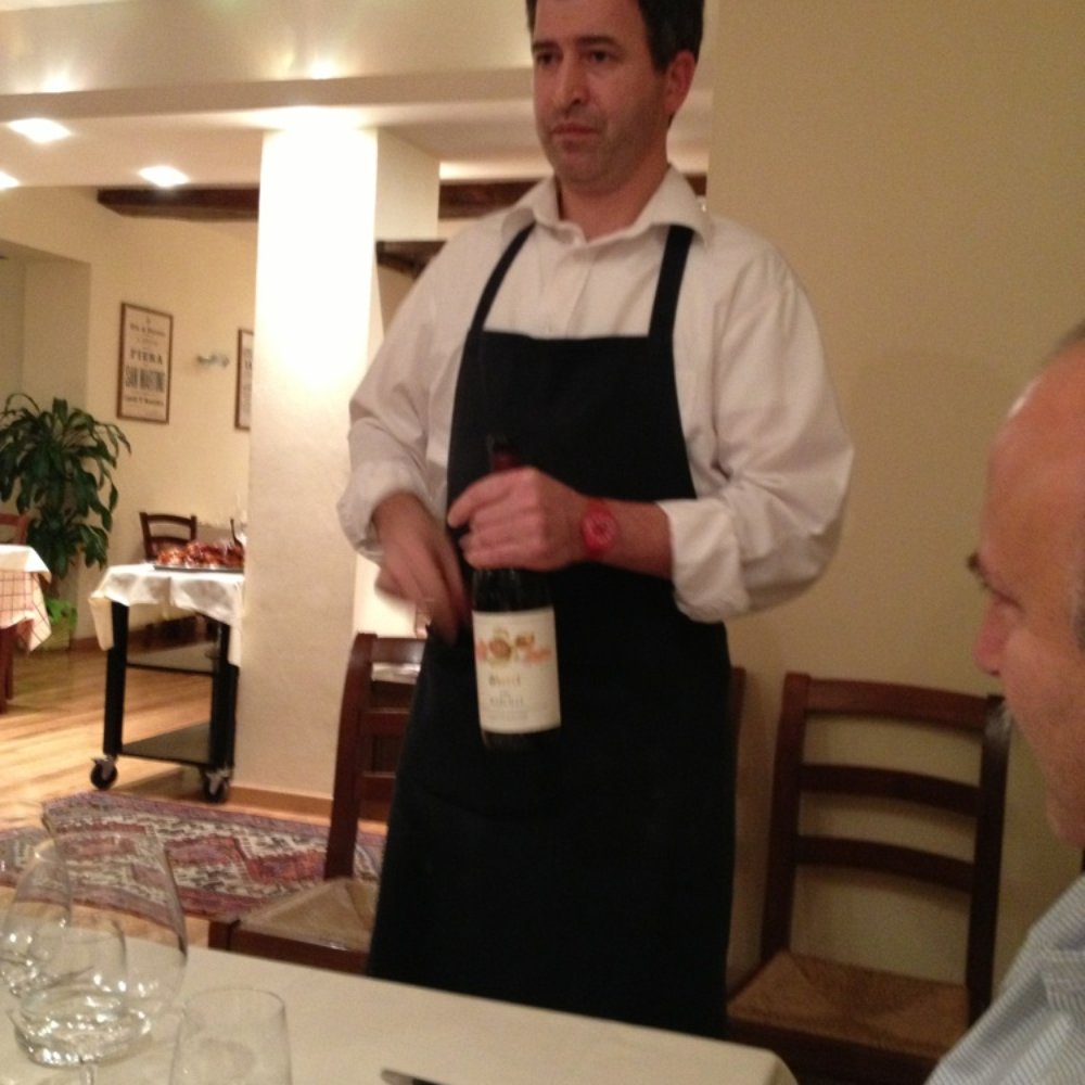 Osteria La Torre - Our waiter opening a bottle of Borolo red wine. - Italian Near Me - Cherasco, CN