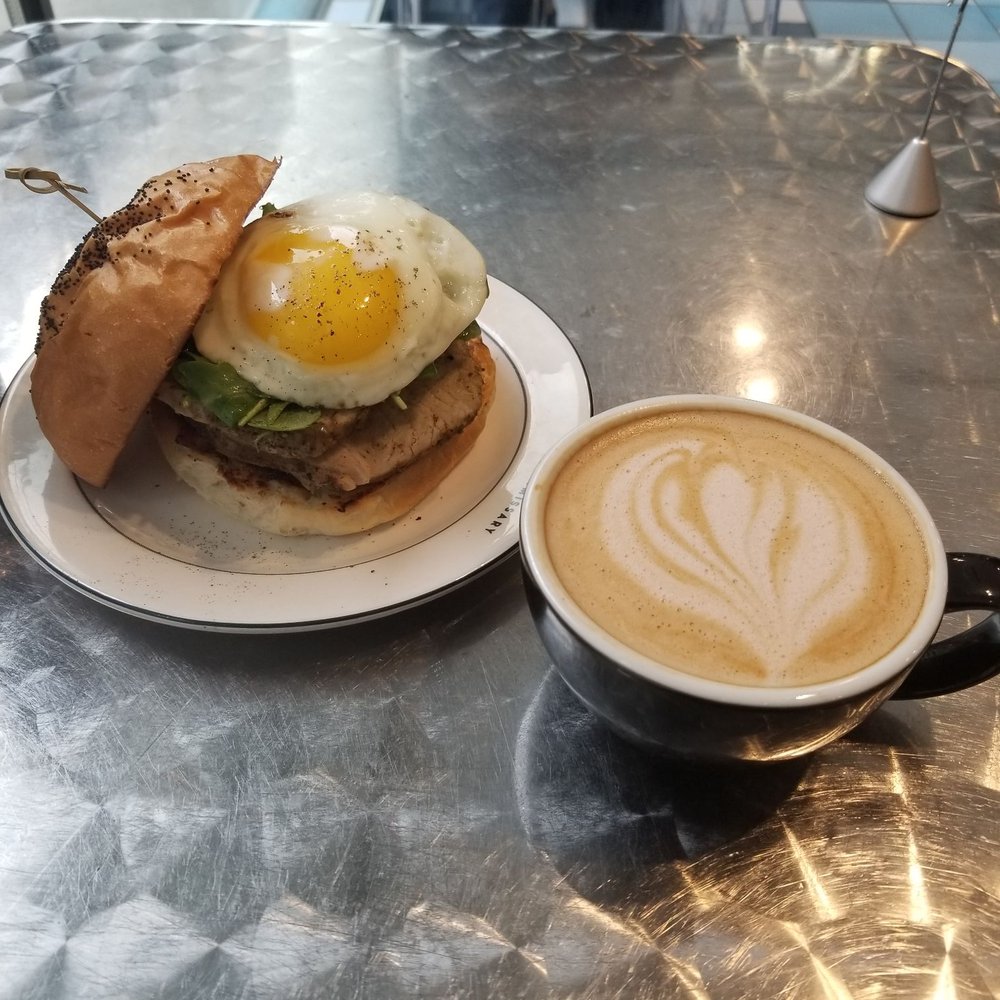 Commissary - The porchetta egg sandwich and a mocha latte with almond milk. - Bakeries Near Me - Dallas, Texas Commissary - The porchetta egg sandwich and a mocha latte with almond milk. - Bakeries Near Me - Dallas, Texas