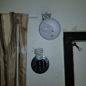 M Motel - a bare bulb and a smoke detector hanging off the wall - Hotels Near Me - El Monte, California