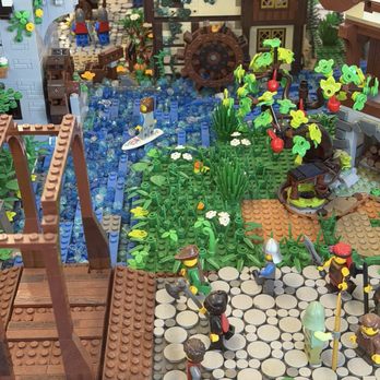 eBricks Outlet - You can tell they actually like and appreciate legos for real - LEGO figures are shown in a detailed village scene with a watermill, a river, and characters in medieval attire, surrounded by plants and buildings. - Toy Stores Near Me - Grand Junction, Colorado