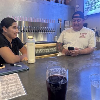 All-American Brew Works - Owner and server with blueberry sour - Breweries Near Me - Anaheim, California All-American Brew Works - Owner and server with blueberry sour - Breweries Near Me - Anaheim, California