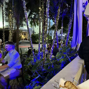 Dolce Italian - a man sitting at a table outside - Italian Near Me - Miami Beach, Florida Dolce Italian - a man sitting at a table outside - Italian Near Me - Miami Beach, Florida