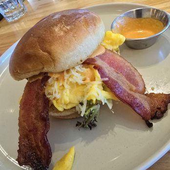 Drift Cafe Village Plaza - Breakfast Sandwich with Scrambled Eggs, Cheese, Bacon, Spring Mix & Roasted Tomato Aioli on a toasted Brioche Bun! - Breakfast & Brunch Near Me - Chapel Hill, North Carolina
