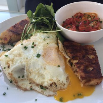 Hangar B Eatery - Savory gruyere bread pudding with two eggs and tomatoes on the side. - Breakfast & Brunch Near Me - Chatham, Massachusetts Hangar B Eatery - Savory gruyere bread pudding with two eggs and tomatoes on the side. - Breakfast & Brunch Near Me - Chatham, Massachusetts