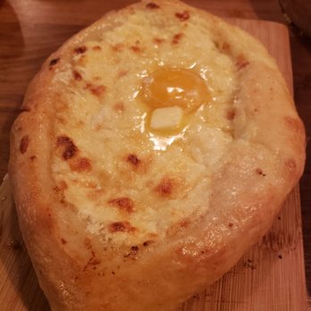 Dediko - Adjuruli - Flat oblong bread filled with fresh house made cheese & topped with and egg - Georgian Near Me - Vancouver, Washington Dediko - Adjuruli - Flat oblong bread filled with fresh house made cheese & topped with and egg - Georgian Near Me - Vancouver, Washington
