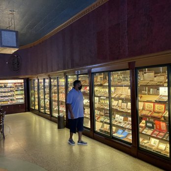 King Corona Cigars - a man standing in front of a display of cigars - Tobacco Shops Near Me - Tampa, Florida King Corona Cigars - a man standing in front of a display of cigars - Tobacco Shops Near Me - Tampa, Florida