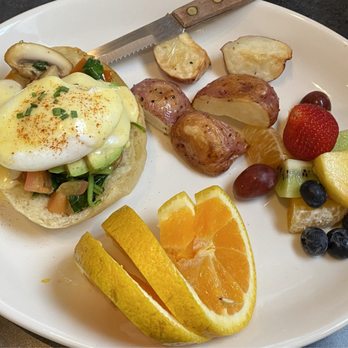 John Street Cafe - a plate of eggs benedicts, fruit, and potatoes - American Near Me - Portland, Oregon