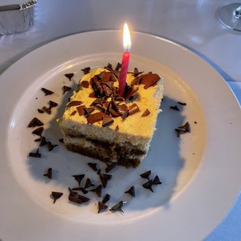 Mangia E Bevi Ristorante - a slice of cake with a lit candle - Italian Near Me - West Vancouver, British Columbia Mangia E Bevi Ristorante - a slice of cake with a lit candle - Italian Near Me - West Vancouver, British Columbia