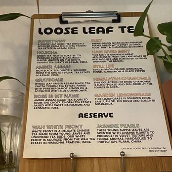 Headrest Coffee - Tea menu - A tea menu printed on paper, listing different loose leaf teas with descriptions, placed on a wooden board with a clip and metal stand. - Bagels Near Me - Brooklyn, New York