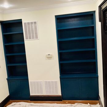 Molina Contractors - a living room with blue bookcases - General Contractors Near Me