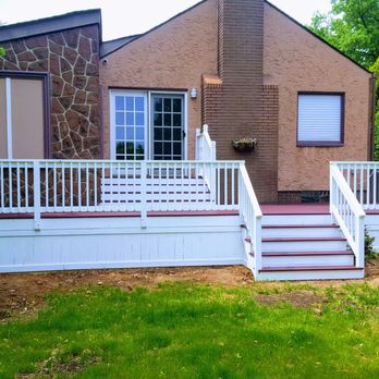 Geg Construction - the front of a home with a deck and stairs - General Contractors Near Me