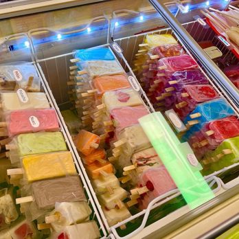 Los 6 Hermanos - A kaleidoscope of mouthwatering frozen confections! - A freezer case contains multiple rows of frozen ice cream popsicles in different colors and flavors, with labels such as 'Piña', 'Nuez', and 'Chocolate'. - Mexican Near Me - Bernalillo, New Mexico
