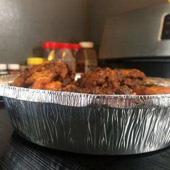 The Smokehouse - a tin foil container of food - Caribbean Near Me - Jamaica, New York