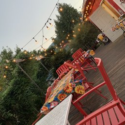 a patio with red chairs and a table