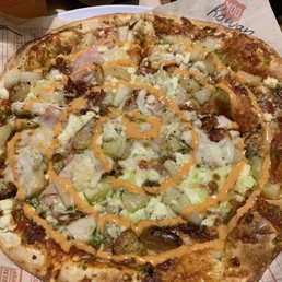 I call this one the cordon blue. Pesto, red sauce, ham, chicken, bacon, pineapple, all cheeses, roasted garlic and finished with Sri-rancha.