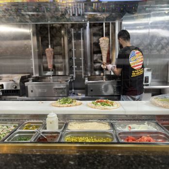 Golden Pockets - a man preparing food in a restaurant kitchen - Halal Near Me - Worcester, Massachusetts