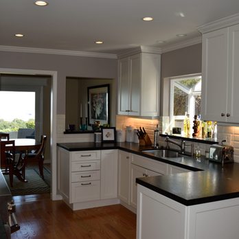 Paul Slattery - a kitchen with white cabinets and black countertops - General Contractors Near Me Paul Slattery - a kitchen with white cabinets and black countertops - General Contractors Near Me