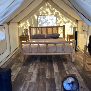 Des Moines West KOA - Inside of Glamping tent. Electrical outlets, fan, king size bed with a very comfortable mattress, side tables and lamps and bench. - Campgrounds Near Me - Adel, Iowa