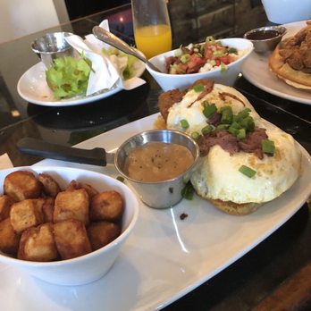 Another Broken Egg Cafe - Country fried Steak Benedict with gravy on the side and an order of breakfast potatoes. Delicious!! - Breakfast & Brunch Near Me - Lafayette, Louisiana