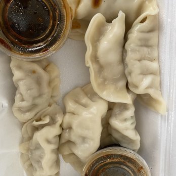 Rose Garden - Steamed Dumplings - Six steamed dumplings with soy sauce in a foam takeout container, likely from a Chinese restaurant. - Fast Food Near Me - Albuquerque, New Mexico