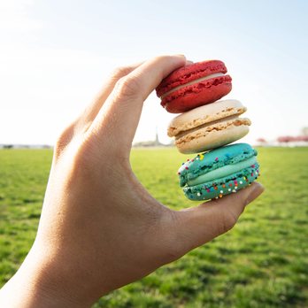 Woops! Macarons & Gifts - Natick Mall - a hand holding a stack of macarons - Macarons Near Me - Natick, Massachusetts Woops! Macarons & Gifts - Natick Mall - a hand holding a stack of macarons - Macarons Near Me - Natick, Massachusetts