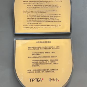TP Tea - Connected to the original boba shop in Taiwan that invented bubble tea. - The image shows two illuminated signs mounted on a wall, one above the other. The top sign details the history of bubble tea, mentioning Chun Shui Tang's role and its signature drinks. The bottom sign contains text in Chinese, describing the origins and development of bubble tea, referencing the same historical points. Both signs are part of the TP TEA establishment, emphasizing its connection to authentic bubble tea history. - Bubble Tea Near Me - Flushing, New York