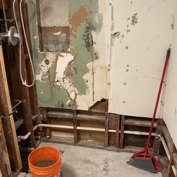 Tile Expressions - a bucket and mop in a bathroom - General Contractors Near Me