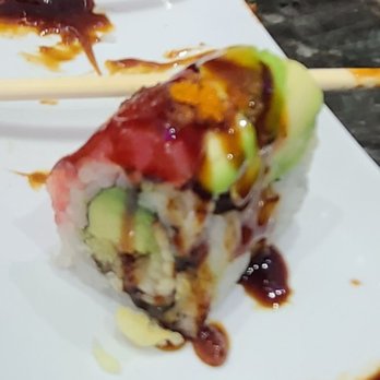 Hibachi Express - Hawaiian roll - A sushi roll with avocado slices, drizzled with sauce and garnished with orange roe, served on a white plate. - Japanese Near Me - Big Spring, Texas