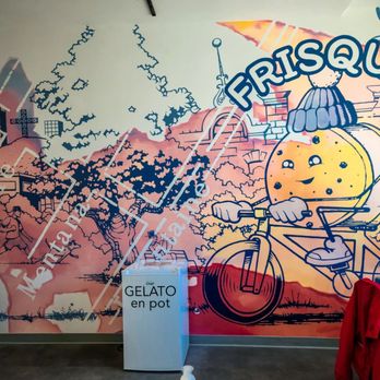 Frisquet - a man riding a bicycle in front of a mural - Ice Cream & Frozen Yogurt Near Me - Montreal, Quebec