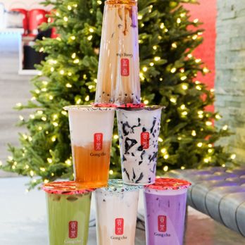 Gong cha - a stack of cups with drinks in front of a christmas tree - Bubble Tea Near Me - Surrey, British Columbia
