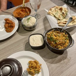 Lamb biryani, butter chicken, garlic naan, and raita. Lamb biryani, butter chicken, garlic naan, and raita.
