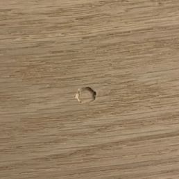 Damaged floor after bed leg was dropped on the floor the screw side down.