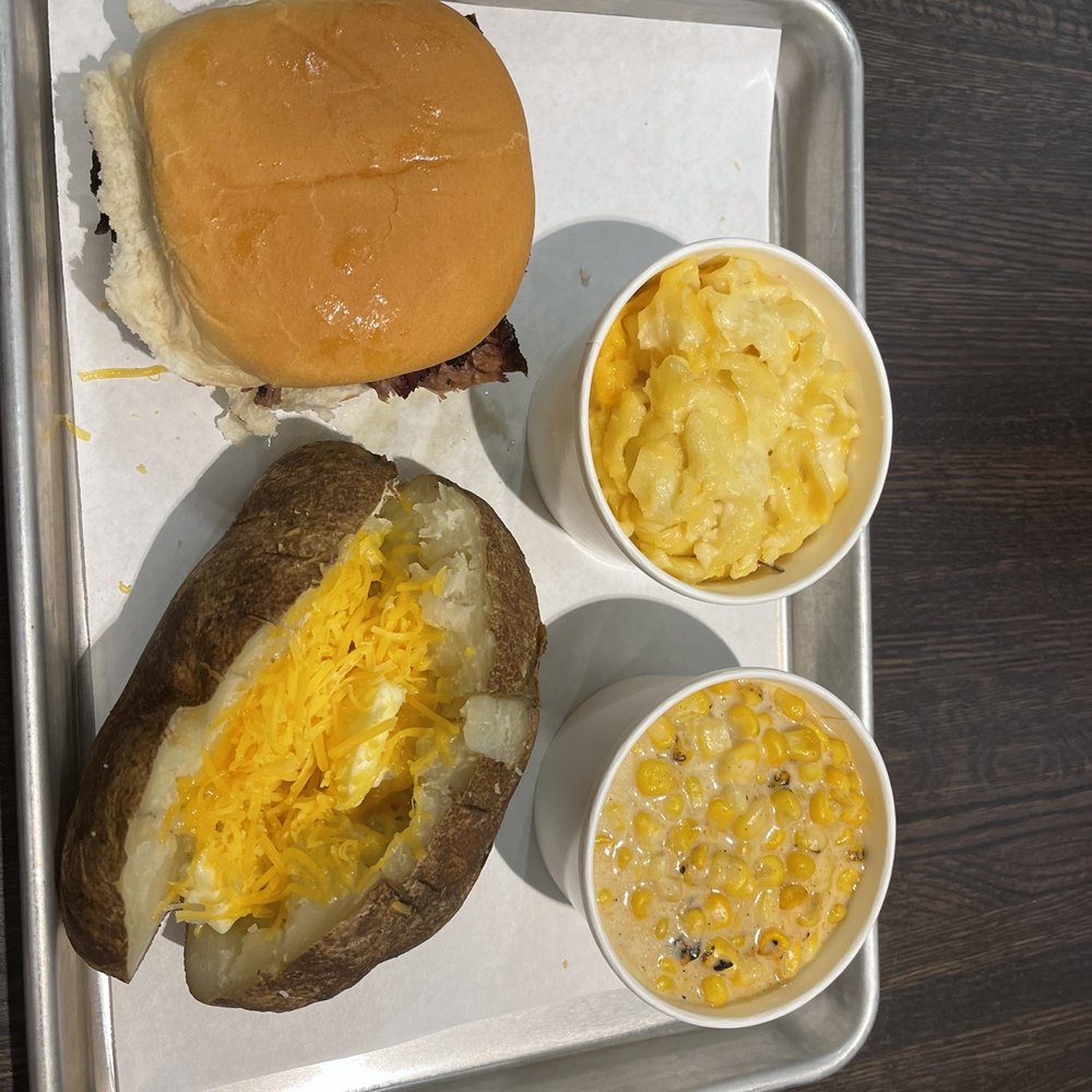 True Texas BBQ - Brisket Sandwich with baked potato, cream corn, and Mac and cheese - Barbeque Near Me - Kerrville, Texas True Texas BBQ - Brisket Sandwich with baked potato, cream corn, and Mac and cheese - Barbeque Near Me - Kerrville, Texas