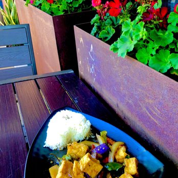 Plumeria - Outdoor seating, blooming geraniums in the flower boxes here at Plumeria. Eggplant tofu dish. - Thai Near Me - San Diego, California
