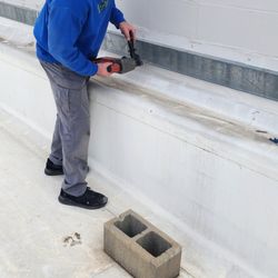 Extermco Termite & Pest Control - Pest Control person performing a wasp exclusion on top of a commercial roof in Fort Smith, AR