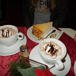 Café Obergfell - Großes Stück Käsekuchen im Hintergrund, vorne die heiße Schokolade
