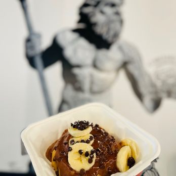 Cinnaholic - a hand holding a container of food - Bakeries Near Me - Virginia Beach, Virginia Cinnaholic - a hand holding a container of food - Bakeries Near Me - Virginia Beach, Virginia