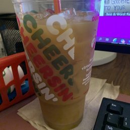 a drink in a plastic cup next to a computer keyboard a drink in a plastic cup next to a computer keyboard