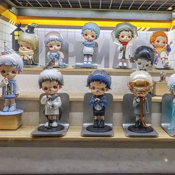 Pop Mart - A display of various small, stylized figurines with distinct features, arranged on tiered wooden shelves in a retail setting. - Toy Stores Near Me - Arcadia, California