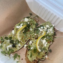Avocado toast with micro greens, lemon garnish, feta cheese red chili flakes and a honey drizzle Avocado toast with micro greens, lemon garnish, feta cheese red chili flakes and a honey drizzle