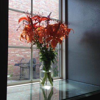The Loaded Toad - a vase of flowers in front of a window - Coffee & Tea Near Me - Glasgow, Montana