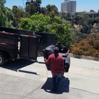 Low Cost Hauling - The VERY HEAVY electric loveseat being quickly whisked away by Juan and his strong partner - Junk Removal & Hauling Near Me