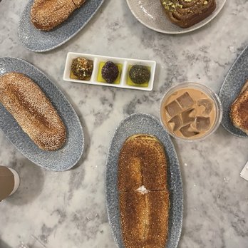 K'Far Cafe - Clockwise: pistachio sticky bun & walnut cinnamon bun babka, iced Yemenite, egg and cheese, marinated labneh - Cafes Near Me - Philadelphia, Pennsylvania
